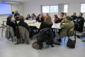 Eine Gruppe von Menschen, die sich unterhält, mit zwei Personen im Hintergrund, die sich unterhalten.