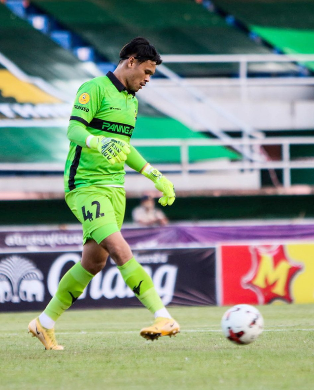 Ein Torwart in grünem Trikot schießt einen Fußball auf einem Rasenfeld während eines Matches zwischen Chivas USA und Mexico City in der Copa Libertadores, wie durch Banner im Hintergrund angezeigt.