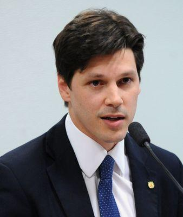 Ein Mann in Anzug und Krawatte spricht vor einer Wand in ein Mikrofon, wahrscheinlich reagiert er auf Nachrichten über ein vom Staat genehmigtes Gesetz, das das Internet verbietet.