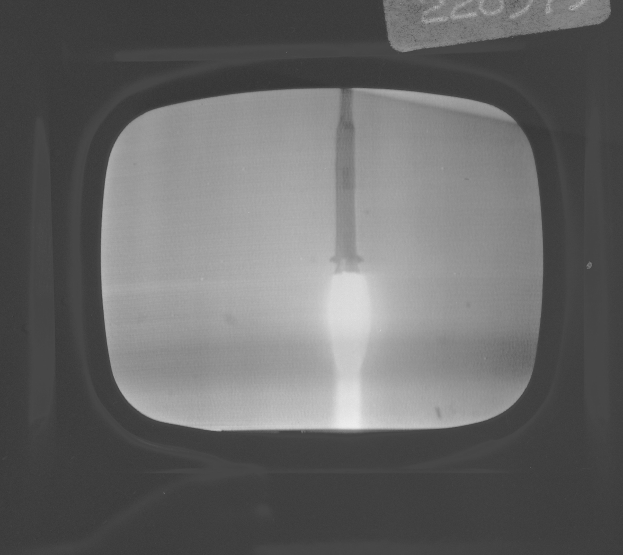 Schwarzes und weißes Foto eines Fernseherbildschirms mit einem Raketenstart durch das Fenster mit Text oben.