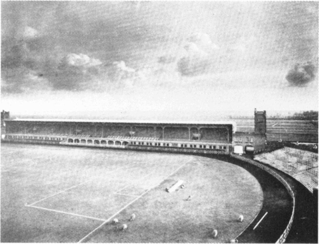 Schwarzes und weißes Foto eines Fußballfeldes mit einem Stadion, das von Bäumen umgeben ist und von einem bewölkten Himmel, beschriftet mit 'Stoke City Football Club' unten.