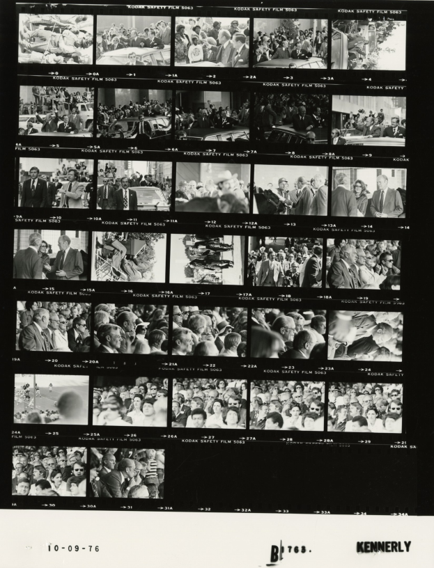 Schwarzes und weißes Foto einer vielseitigen Menge, die um einen Fernseher versammelt ist und lacht, mit Text am unteren Rand.