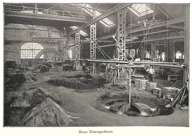 Schwarzes und weißes Foto einer Fabrik mit Arbeitern, die Maschinen bedienen, umgeben von Metallstangen und Pfählen, beschriftet mit "Neue Eisengießerei, die erste Fabrik in Deutschland" unten.