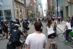 Gebäude säumen eine Straße mit wenigen Menschen auf Fahrrädern.
