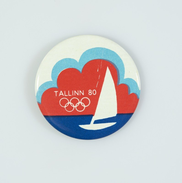Ein weißer Abzeichen mit einem Segelboot-Grafik und dem Text "Tallinn 80 Olympische Spiele", zum 80. Jahrestag der Olympischen Spiele in Tallinn.