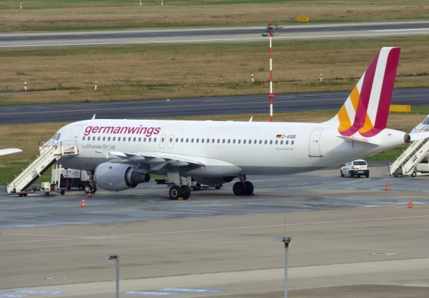 Ein Airbus A320-200 der Germanwings auf dem Frankfurt Airport mit Fahrzeugen, Verkehrskegeln, Pfählen und Gras im Hintergrund.
