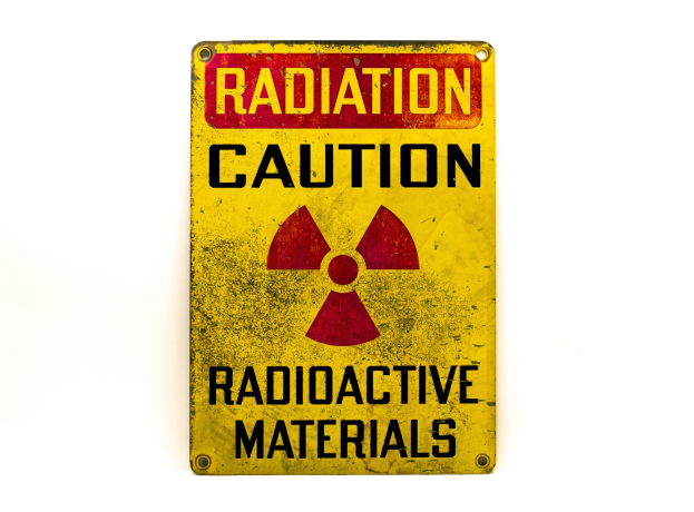 Gelbes Warnschild mit schwarzer "Strahlungswarnung"-Text und einem radioaktiven Symbol auf einem weißen Hintergrund.