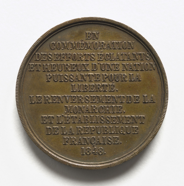 Bronzene Medaille mit der Inschrift "Würdigung der Herausragenden und Glücklichen Anstrengungen einer Nation" auf weißem Hintergrund.