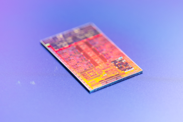 Nahaufnahme eines Mikrochips, der als neuer Intel-Prozessor auf einer blauen Oberfläche etikettiert ist.